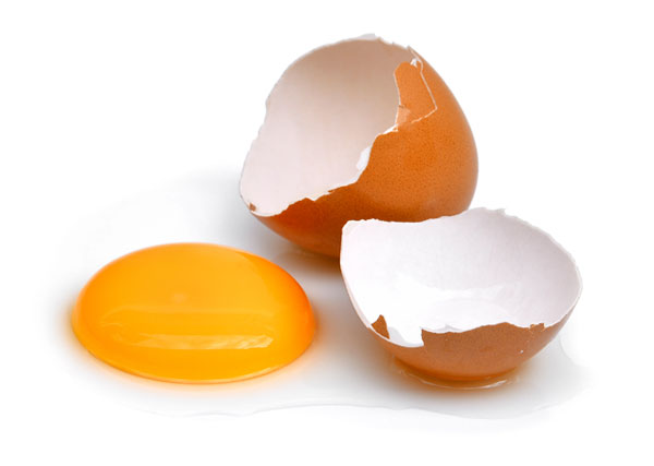 Cracked egg with yolk on table